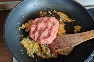 When the onions and garlic are lightly browned, add the meat and fry well